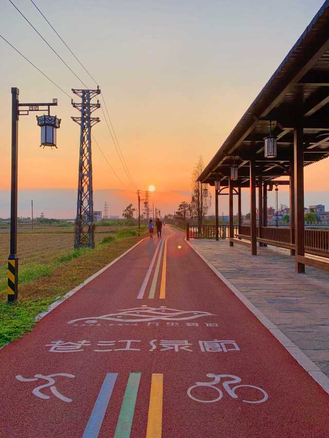 黃昏時分，人們迎著夕陽在蒼江綠廊漫步